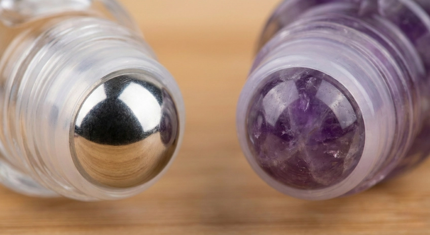Macro shot comparing stainless steel and gemstone roller balls with different oil viscosities