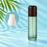 Frosted green glass lotion bottle with rounded dark wood cap and white pump detail inset on a light cyan scene with visible palm leaves