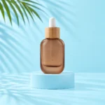 Frosted brown glass dropper bottle with natural bamboo collar and white bulb on a pale blue cylinder.