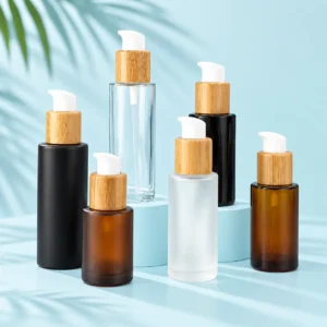 Glass lotion pump bottles in black, amber, clear and frosted finishes with bamboo collars