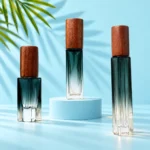 Three green-to-clear gradient glass perfume bottles with dark walnut caps on matching mint platforms with green palm leaves