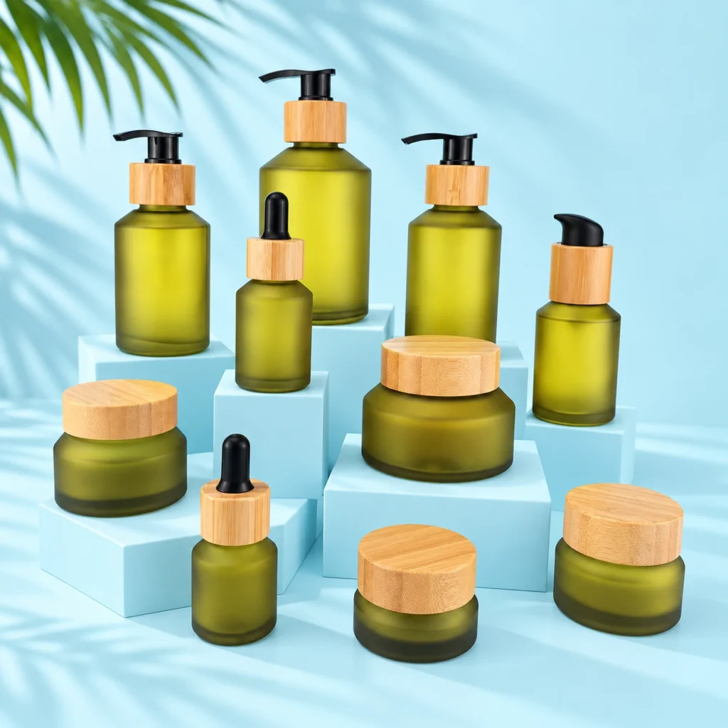 Olive green glass skincare bottles and cream jars with bamboo closures on matching pale blue cyan display blocks