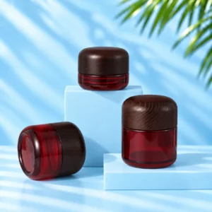 Three red glass cream jars with rounded dark wood lids displayed at different angles on cyan platforms.