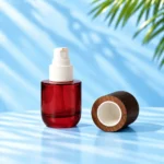 Compact red glass lotion bottle with an exposed white pump and detached rounded wood cap resting on a cyan tabletop.