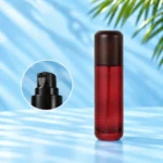 Tall red glass lotion bottle with a rounded dark wood cap and an inset showing the black lotion pump.