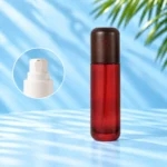Tall red glass lotion bottle with a rounded dark wood cap and an inset showing the white lotion pump.