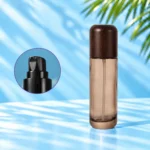 Tall smoke gray glass lotion bottle with rounded wood cap and a close-up inset of the black lotion pump.