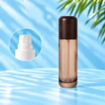 Tall smoke gray glass lotion bottle with rounded wood cap and a close-up inset of the white lotion pump.