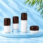 Three opaque white lotion bottles and a matching white cream jar with rounded dark wood closures on a cyan circular platform.